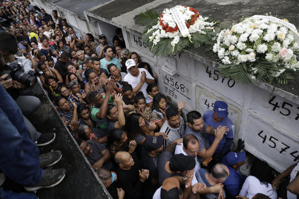 Relatives and friends applaud in honor of the late 8-year-old Ágatha Sales Felix, who was hit by a a stray bullet, as they bury her at the cemetery in Rio de Janeiro, Brazil, Sunday, Sept. 22, 2019. Félix was hit by a stray bullet Friday amid what police said was shootout with suspected criminals. However, residents say there was no shootout, and blame police. (AP Photo/Silvia Izquierdo)