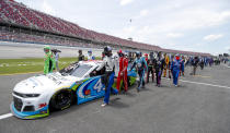 Nascar drivers Kyle Busch, left, and Corey LaJoie, right, join other drivers and crews as they push the car of Bubba Wallace to the front of the field prior to the start of the NASCAR Cup Series auto race at the Talladega Superspeedway in Talladega Ala., Monday June 22, 2020. In an extraordinary act of solidarity with NASCAR’s only Black driver, dozens of drivers pushed the car belonging to Bubba Wallace to the front of the field before Monday’s race as FBI agents nearby tried to find out who left a noose in his garage stall over the weekend.(AP Photo/John Bazemore)