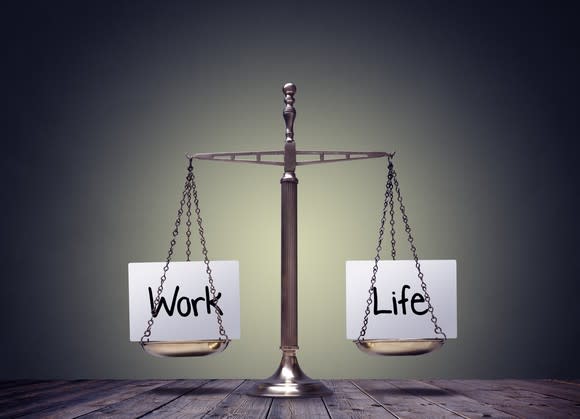 A balance scale carries the words work and life.