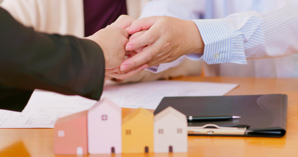 close up shot of elderly asian couple are buying house with real estate agent and make a deal then they shake hands