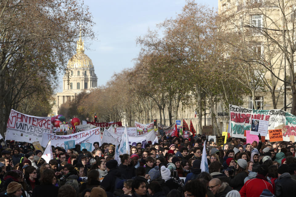 People march with banners during a demonstration Tuesday, Dec. 10, 2019 in Paris. French airport employees, teachers and other workers joined nationwide strikes Tuesday as unions cranked up pressure on the government to scrap upcoming changes to the country's national retirement system. (AP Photo/Thibault Camus)