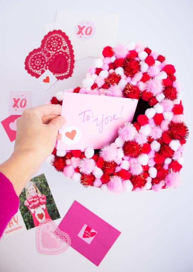 <p>Glue a bunch of festive pom-poms on a heart-shaped box and call it a day. Seriously, it's that simple. Decorate it with an assortment of pink, red and white pom-poms and use a hot glue gun to keep them in place. </p><p><em><a href="https://designimprovised.com/2016/02/diy-pom-pom-heart-valentine-card-holder-box.html" rel="nofollow noopener" target="_blank" data-ylk="slk:Get the tutorial at Design Improvised »;elm:context_link;itc:0" class="link ">Get the tutorial at Design Improvised »</a></em></p>