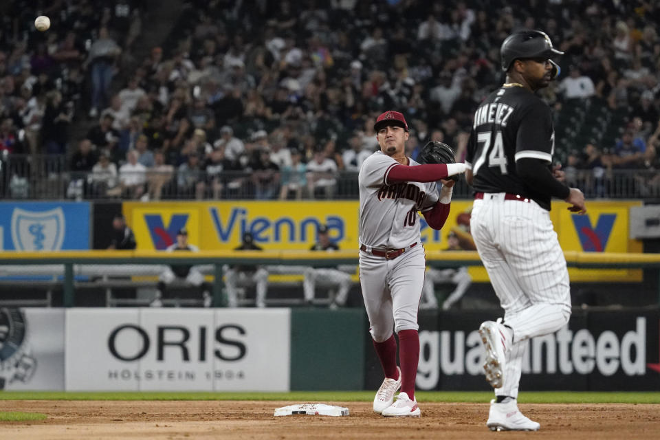 Arizona Diamondbacks second baseman Josh Rojas, left, throws out Chicago White Sox's AJ Pollock at first base after forcing out Eloy Jimenez at second base during the second inning of a baseball game in Chicago, Friday, Aug. 26, 2022. (AP Photo/Nam Y. Huh)