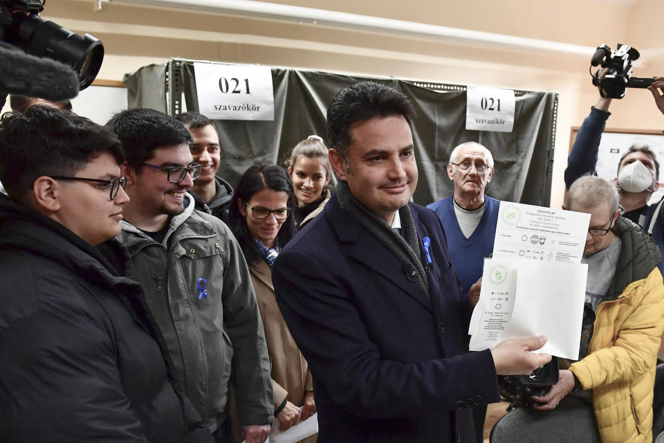 Opposition leader Peter Marki-Zay shows his ballot papers prior to voting in general election in Hodmezovasarhely, southern Hungary, Sunday, April 3, 2022. Hungary's nationalist prime minister, Viktor Orban, seeks a fourth straight term in office, a coalition of opposition parties are framing the election as a referendum on Hungary's future in the West. (AP Photo/Anna Szilagyi)