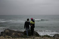 FILE - In this April 14, 2018 file photo, Ahmed Ayouby, 32, left, and Mounir Aguida, 30, who want to leave Tunisia, stand at the beach where migrants leave for Italy, in the town of Ras Jabal, Bizerte, Tunisia. The number of Tunisians migrating clandestinely to Italy has risen to levels not seen since the 2011 Arab Spring uprising. That's causing tensions in Italy's south, where more than 2,200 migrants are quarantining on ferries anchored offshore. (AP Photo/Nariman El-Mofty, File)