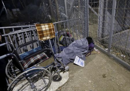 Stranded wheelchair-bound Zhino Hasan, 17, is seen in front of the closed Idomeni border gate, hoping that Macedonia would relent and allow her and her family to resume their northward trek through the Balkans to Germany February 26, 2016. REUTERS/Yannis Behrakis