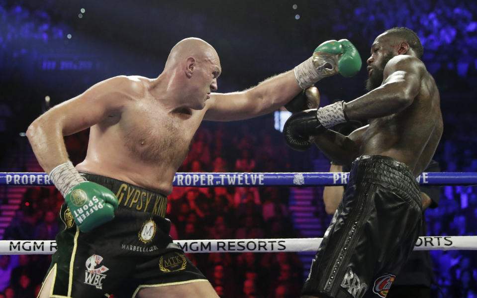 El inglés Tyson Fury, a la izquierda, pelea contra Deontay Wilder por el título de pesos pesados de la WBC, el sábado 22 de febrero de 2020 en Las Vegas. (AP Foto/Isaac Brekken)