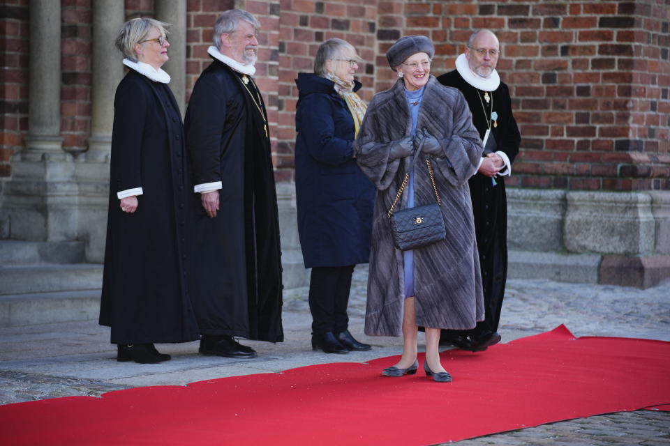 La reina Margarita, frente al centro, sonríe al caminar hacia la tumba de su padre fuera de la catedral de Roskilde en el 50 aniversario de su reinado en el Castillo de Christiansborg en Copenhague el 14 de enero de 2022. La popular monarca de Dinamarca festejó el aniversario con eventos discretos por la pandemia. El resto de las celebraciones se aplazó para septiembre. (Claus Bech/Ritzau Scanpix via AP)