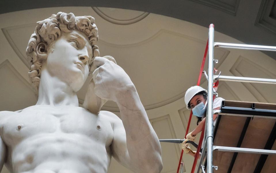 A restorer cleans Michelangelo's David statue while preparing for the reopening of the Galleria dell'Accademia, which was closed for almost three months due to coronavirus  - Getty