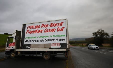 A damaged lorry advertising a 'Pre-Brexit sale' is seen by the road close to the border in Londonderry, Northern Ireland