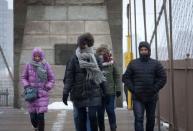 People walk across the Brooklyn Bridge towards the Brooklyn borough of New York City as a winter storm begins in New York, January 26, 2015. REUTERS/Stephanie Keith