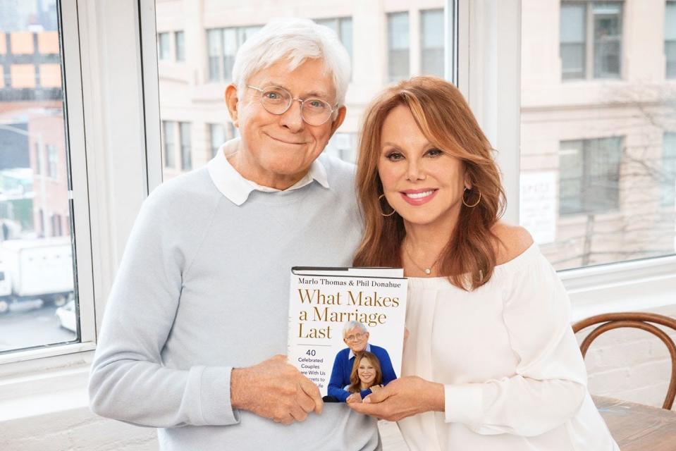 Phil Donahue and Marlo Thomas hold a copy of their book, "What Makes a Marriage Last," available now.