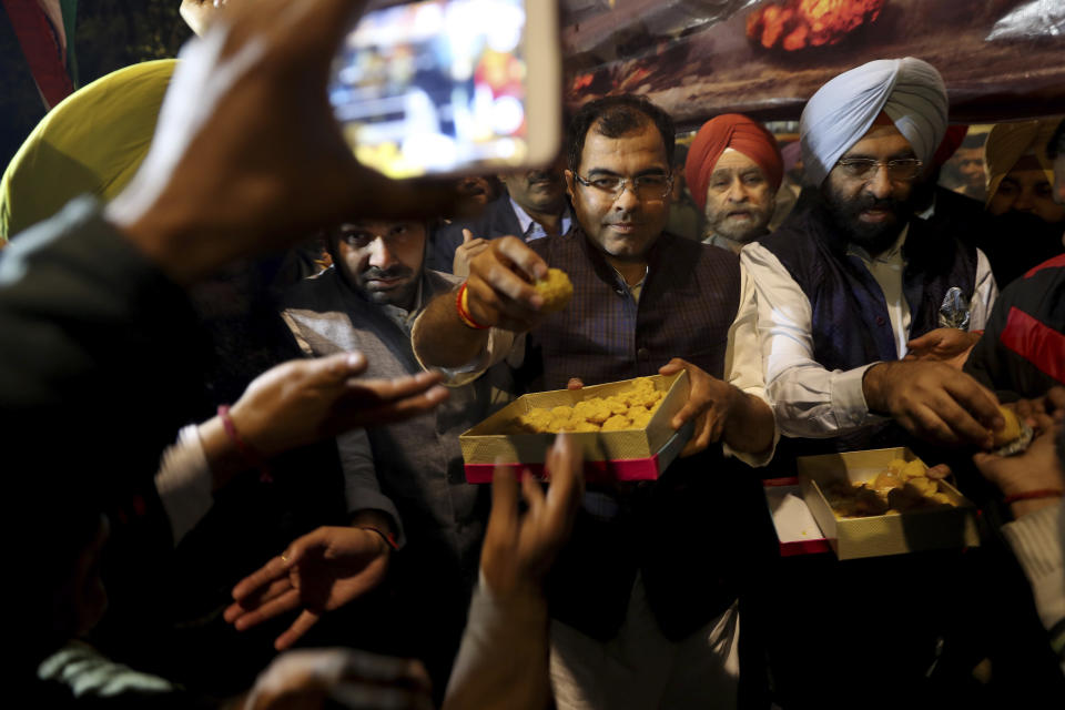 India's ruling Bhartiya Janata Party leaders distribute sweets as they celebrate reports of Indian aircrafts bombing Pakistan territory, in New Delhi, India, Tuesday, Feb. 26, 2019. A pre-dawn airstrike inside Pakistan that India said targeted a terrorist training camp and killed a "very large number" of militants ratcheted up tensions on Tuesday between the two nuclear-armed rivals at odds over the disputed territory of Kashmir. (AP Photo/Altaf Qadri)