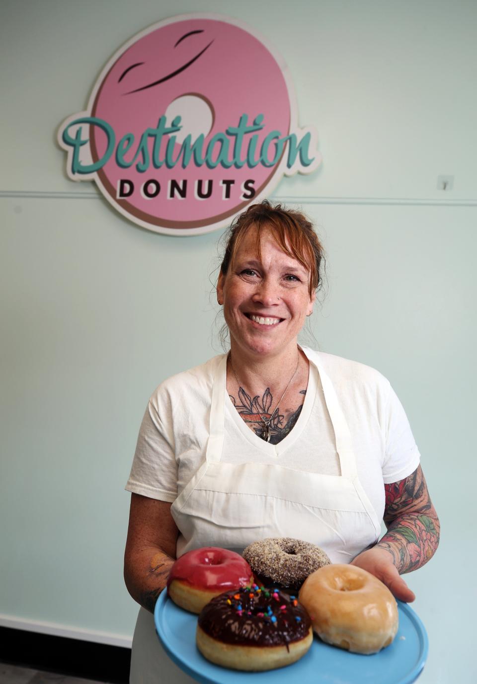 Destination Donuts owner Heather Morris displays a plate of doughnuts at the new Clintonville store at 3519 N. High St., which was opened April 7.