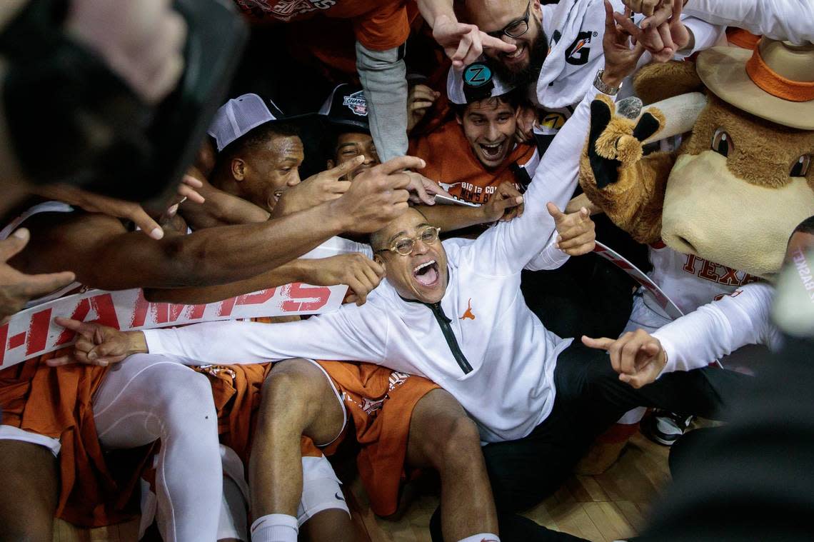 Texas interim coach Rodney Terry dives into a pile of players celebrating the Big 12 Championship after Saturday’s win against Kansas.