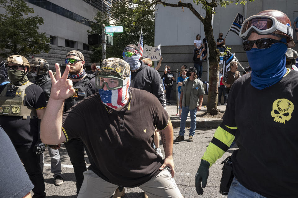 An associate of the Proud Boys, a far-right group with a history of engaging in violent street clashes, flashes the once innocuous “OK” hand sign—now co-opted by white supremacists—at counter demonstrators during a rally in Portland, Ore., Aug. 22, 2020.<span class="copyright">Rian Dundon</span>