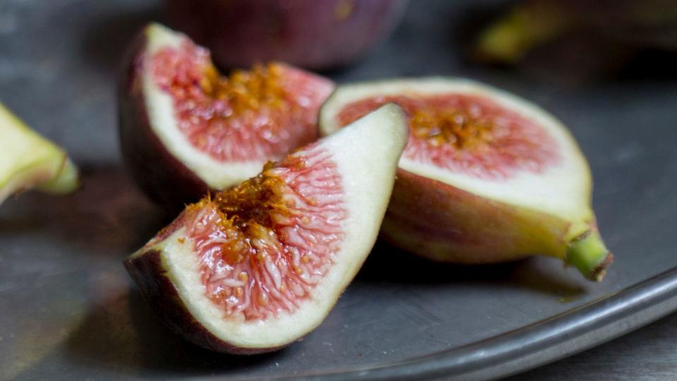 Split figs sitting on black slate plate