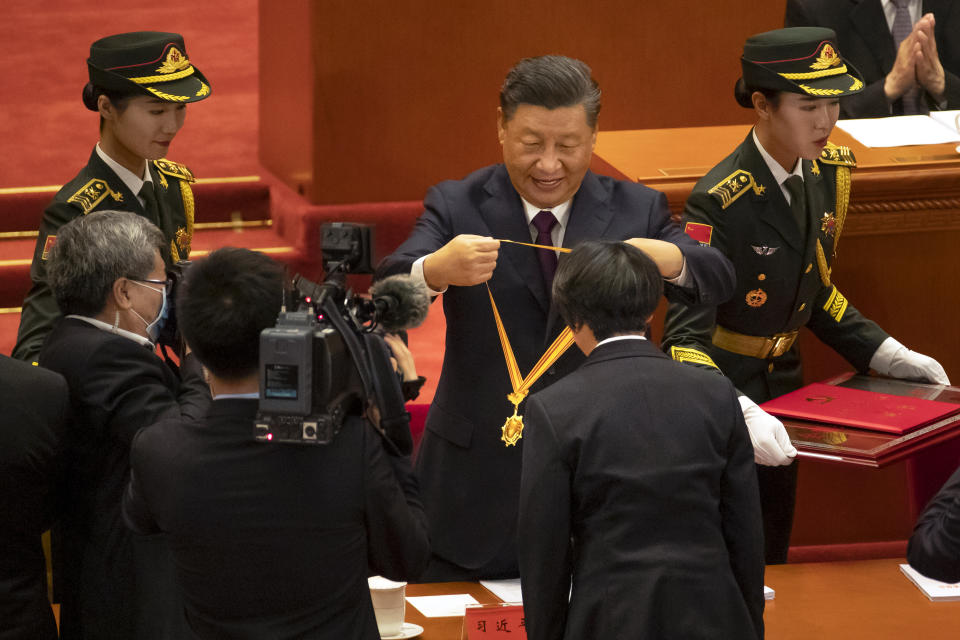 Chinese President Xi Jinping, rear center, presents a medal to an honoree at an event to honor some of those involved in China's fight against COVID-19 at the Great Hall of the People in Beijing, Tuesday, Sept. 8, 2020. Chinese leader Xi Jinping is praising China's role in battling the global coronavirus pandemic and expressing support for the U.N.'s World Health Organization, in a repudiation of U.S. criticism and a bid to rally domestic support for Communist Party leadership. (AP Photo/Mark Schiefelbein)