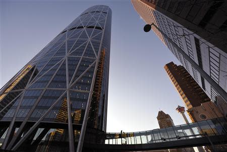 Steel workers construct an elevated indoor walkway to the new Bow skyscraper (L) in downtown Calgary, Alberta in this January 26, 2012 file photo. REUTERS/Todd Korol/Files