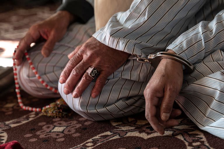 Un hombre afgano que ha sido condenado a muerte por asesinato, esposado a otro preso durante una audiencia en el Tribunal de Apelaciones de Ghazni