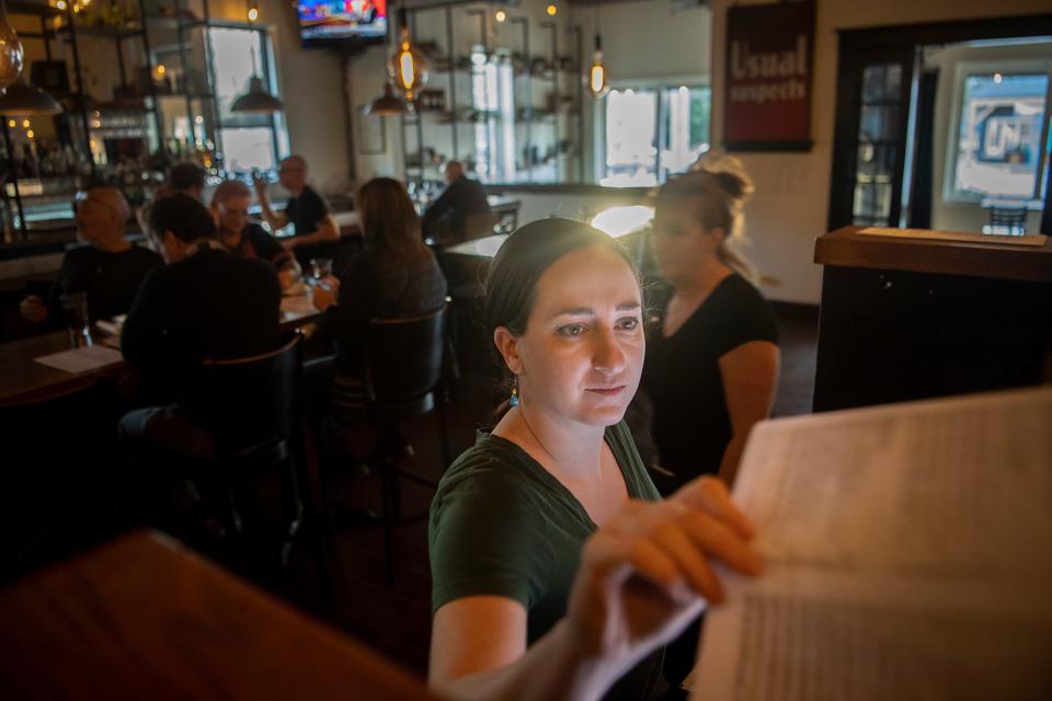 Rachel Gordon grabs a menu while entering drink orders for a party of eight, February 7, 2024, at Avenue M.