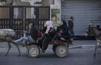 Palestinians flee their homes after overnight Israeli heavy missile strikes on their neighborhoods in the outskirts of Gaza City, Friday, May 14, 2021. (AP Photo/Khalil Hamra)