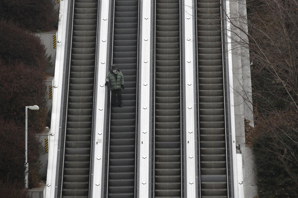 A man wearing a face mask as a precaution against the coronavirus takes the escalator down in Seoul, South Korea, Sunday, Dec. 13, 2020. (AP Photo/Lee Jin-man)