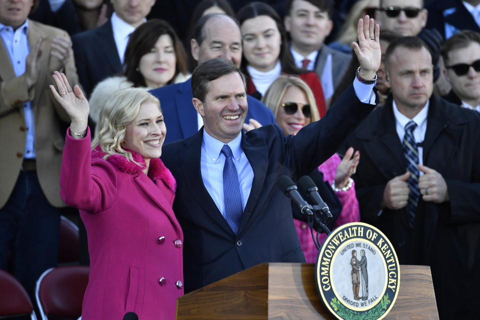 Kentucky Governor Andy Beshear, right, and his wife Britainy, wave to the crowd gathered to witness his public swearing in on the steps of the Kentucky State Capitol in Frankfort, Ky., Tuesday, Dec. 12, 2023. (AP Photo/Timothy D. Easley)