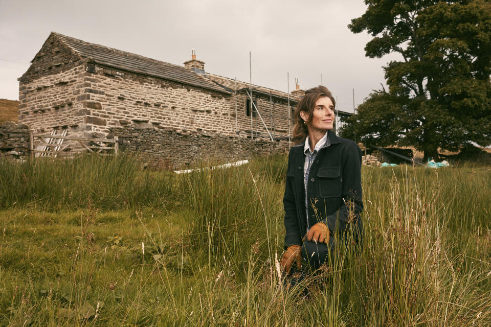 Amanda Owen in the long grass outside of the farm