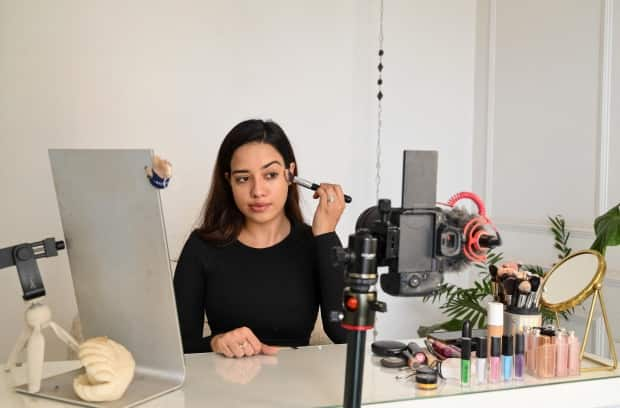 In this photo taken on March 16, 2023, social media beauty and lifestyle influencer Debasree Banerjee does her make-up while going live on her YouTube channel in Mumbai. 