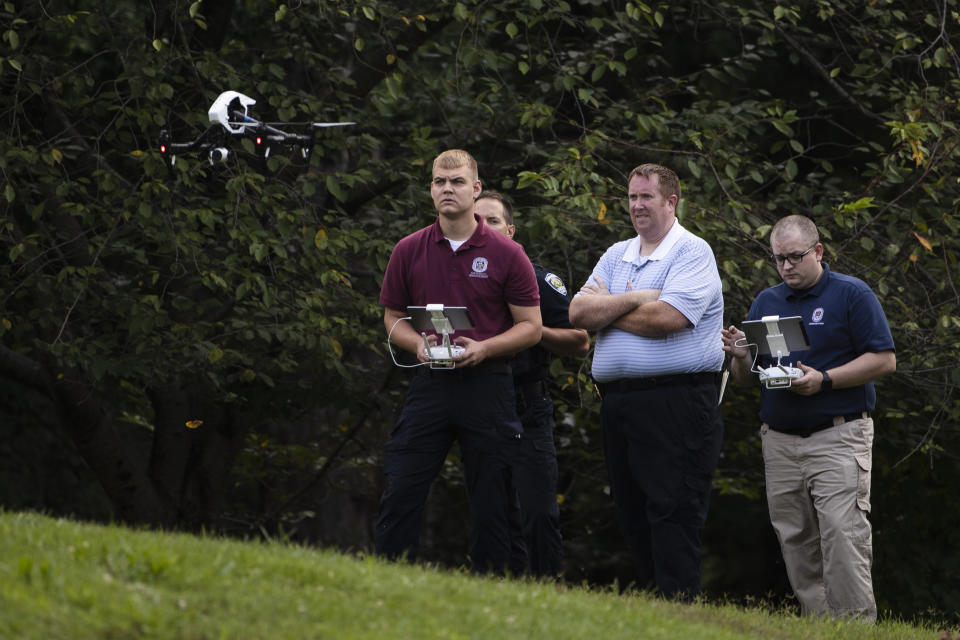 Investigators launch a drone at scene of a small plane crash in a residential neighborhood in Upper Moreland, Pa., Thursday, Aug. 8, 2019. Upper Moreland Police Chief Michael Murphy says the plane hit several trees before it finally came to rest. He said everyone aboard the plane was killed. (AP Photo/Matt Rourke)