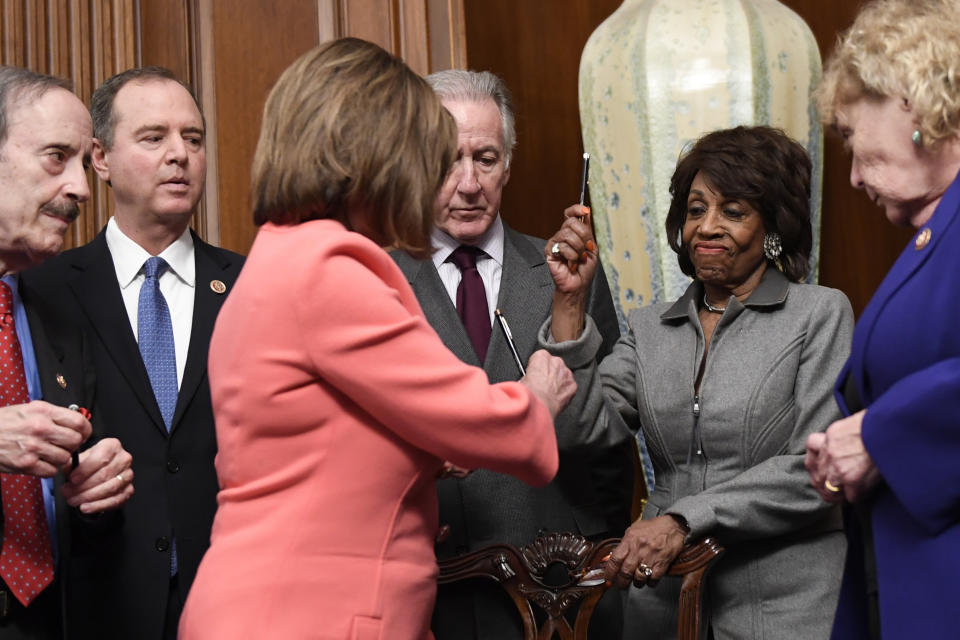 House Financial Services Committee Chairwoman Maxine Waters, D-Calif., second from right, reacts after getting a pen from House Speaker Nancy Pelosi of Calif., after she signed the resolution to transmit the two articles of impeachment against President Donald Trump to the Senate for trial on Capitol Hill in Washington, Wednesday, Jan. 15, 2020. The two articles of impeachment against Trump are for abuse of power and obstruction of Congress. Other looking on are, from left, House Foreign Affairs Committee Chairman Rep. Eliot Engel, D.-N.Y., House Intelligence Committee Chairman Adam Schiff, D-Calif., House Ways and Means Committee Chairman Rep. Richard Neal, D-Mass., and Rep. Zoe Lofgren, D-California. (AP Photo/Susan Walsh)