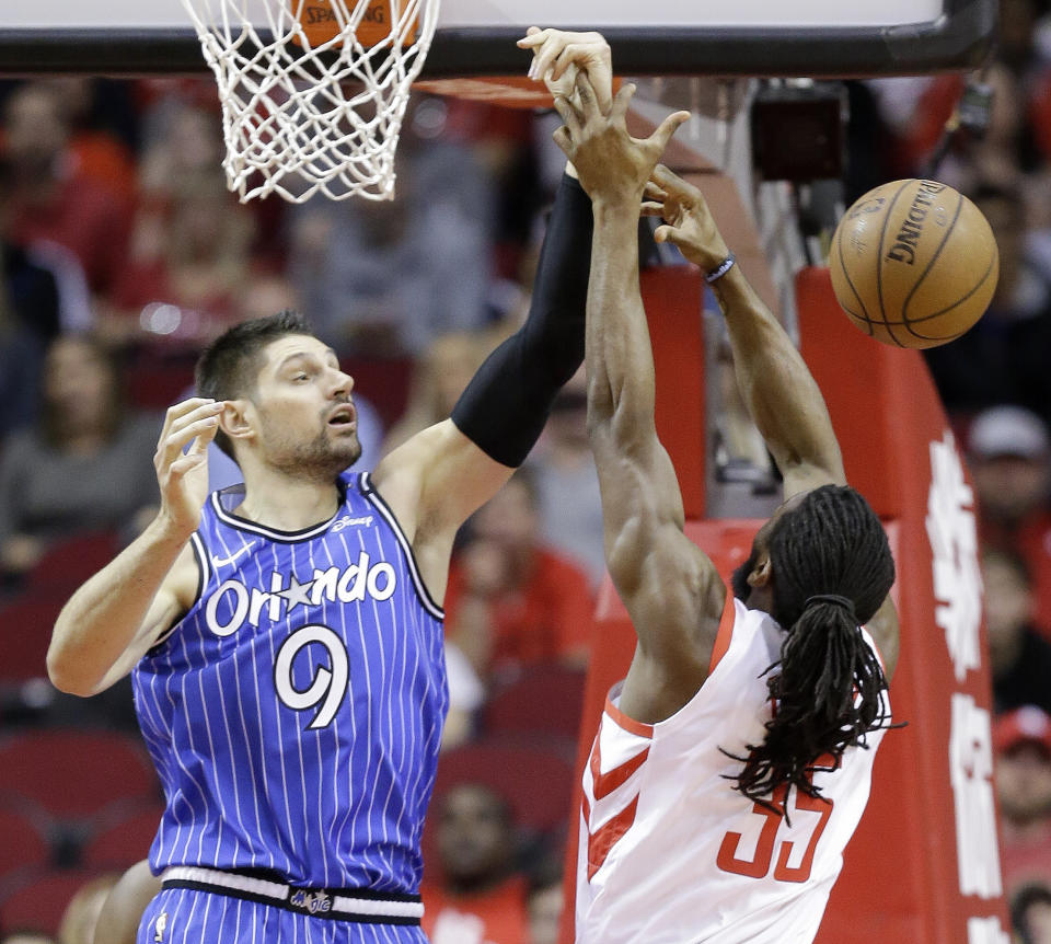 Orlando Magic center Nikola Vucevic (9) and Houston Rockets forward Kenneth Faried vie for a rebound during the first half of an NBA basketball game, Sunday, Jan. 27, 2019, in Houston. (AP Photo/Eric Christian Smith)