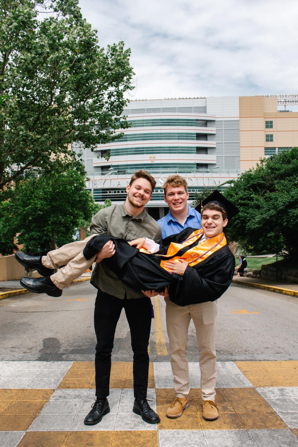 From left to right, Miles and Coleman Kredich holding up Ben Kredich in front of Neyland Stadium.