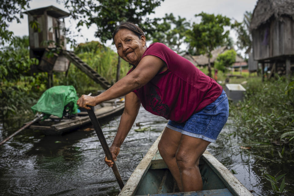 Lindaura Pinedo Rios heads out on her boat to attend a funeral service for a Maijuna elder, in Sucusari, Peru, Wednesday, May 29, 2024. A federal highway project in an untouched area of the Peruvian Amazon is facing mounting opposition from Indigenous tribes, including the Maijuna. (AP Photo/Rodrigo Abd)