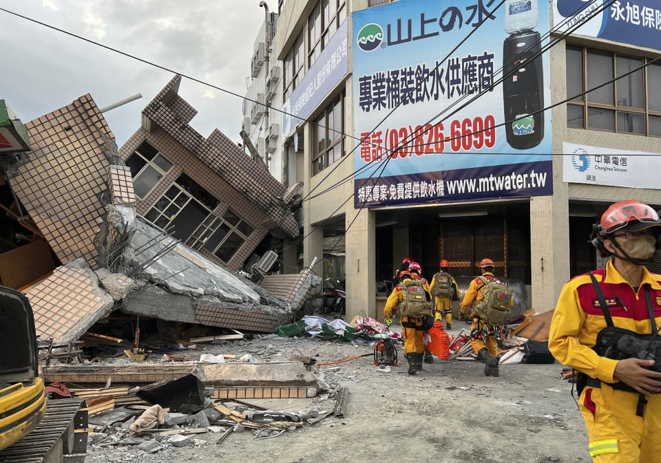 This photo provided by Hualien County fire department show firefighters in the search for trapped victims in a collapsed residential building following earthquake in Yuli township in Hualien County, eastern Taiwan, Sunday, Sept. 18, 2022. A strong earthquake shook much of Taiwan on Sunday, toppling at least one building and trapping two people inside and knocking part of a passenger train off its tracks at a station.(Hualien County Fire Department via AP)
