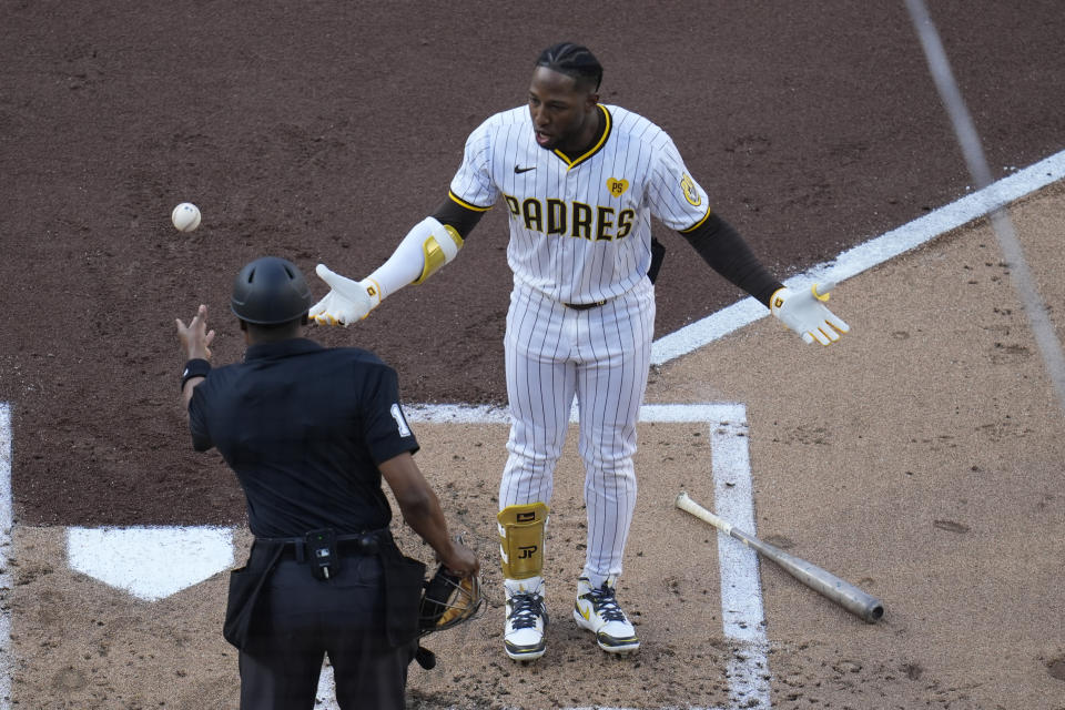 San Diego Padres' Jurickson Profar, right, reacts after being ejected by home plate umpire Ramon De Jesus during the second inning of the team's baseball game against the Toronto Blue Jays, Saturday, April 20, 2024, in San Diego. (AP Photo/Gregory Bull)