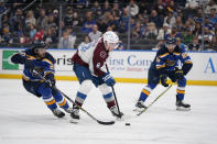 Colorado Avalanche's Cale Makar (8) handles the puck as St. Louis Blues' Brandon Saad (20) and Jordan Kyrou (25) defend during the third period in Game 3 of an NHL hockey Stanley Cup second-round playoff series Saturday, May 21, 2022, in St. Louis. (AP Photo/Jeff Roberson)