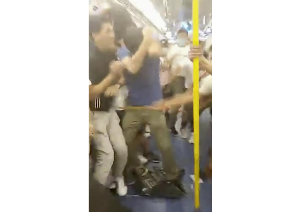 This Sunday, July 21, 2019, image made from a video, shows fighting inside a train car in Hong Kong. Protesters trying to return home were attacked inside a train station by assailants who appeared to target the pro-democracy demonstrators. (Lam Cheuk-ting via AP)