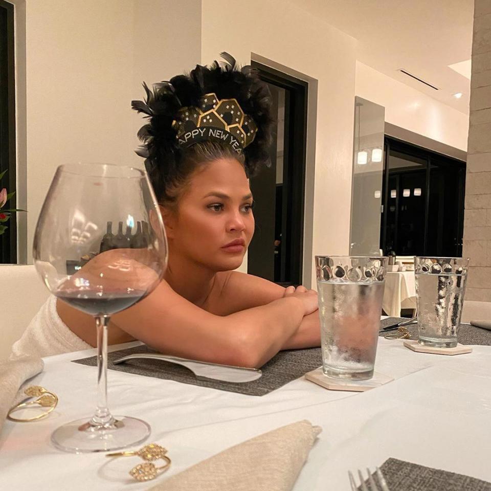 Chrissy Teigen seated at a table