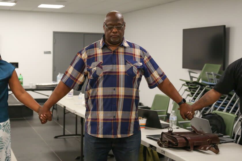 LOS ANGELES, CA - AUGUST 25: Crisis interventionist Kevin Orange (center), Executive Director of Advocates 4 Peace & Urban Unity, hold hand in prayer with a group of crisis interventionist from across the country during a peer learning exchange collaborative focusing on community violence intervention on Thursday, Aug. 25, 2022 in Los Angeles, CA. (Jason Armond / Los Angeles Times)