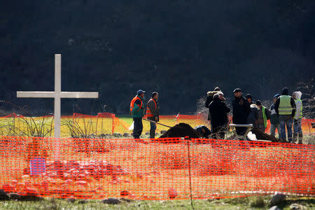 Workers are seen standing near the area where they exhumed the bodies of Greek World War Two soldiers in the Sajmola Valley, Dragot, Tepelena, Albania January 24, 2018. Picture taken January 24, 2018. REUTERS/Florion Goga