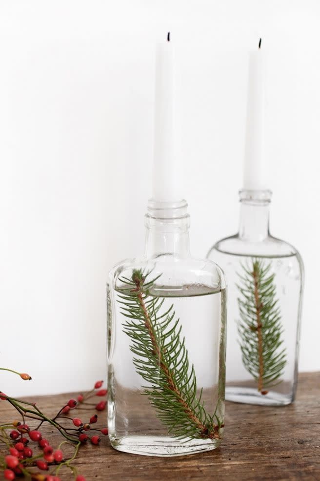 <p>Place cut sprigs of pine in skinny-necked, water-filled bottles and top with tapered candles for a stunning and simple arrangement.</p><p>Get the tutorial at <a href="http://themerrythought.com/christmas-2/tree-branch-christmas-display/" rel="nofollow noopener" target="_blank" data-ylk="slk:The Merrythought;elm:context_link;itc:0;sec:content-canvas" class="link ">The Merrythought</a>.</p>