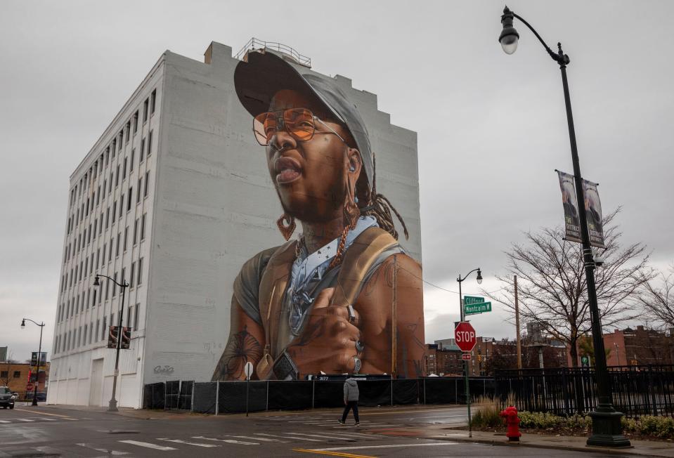 A person walks by a building in downtown Detroit displaying a giant mural of Detroit artist Bakpak Durden on Wednesday, Nov. 8, 2023. The mural was created by an Australian artist named Smug.
(Credit: David Rodriguez Munoz, Detroit Free Press)