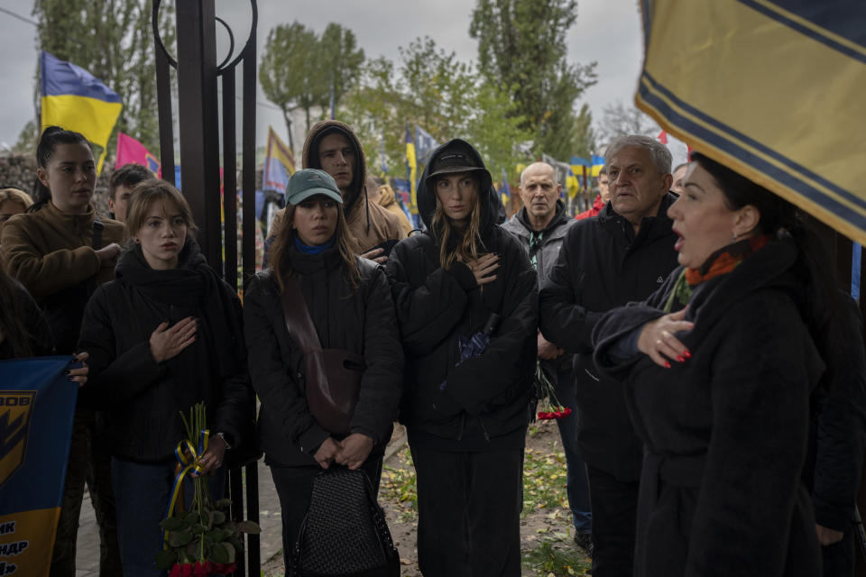 People sing the Ukrainian national anthem at the funeral of Ukrainian soldier Oleksandr Hrianyk in Kyiv, Ukraine, Saturday, Oct. 28, 2023. Hrianyk died in battle in May 2022 in the city of Mariupol, but was only cremated recently after his remains were found and identified. (AP Photo/Bram Janssen)