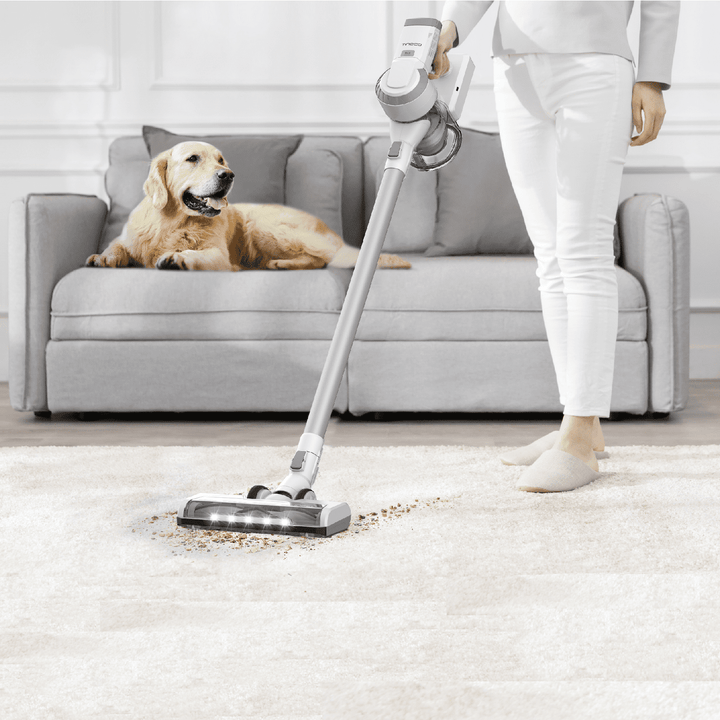 someone vacuuming dirt off of a rug