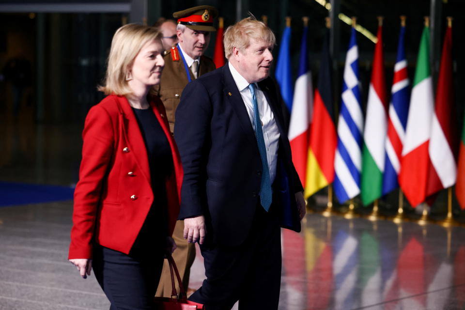  Foreign Secretary Liz Truss and Prime Minister Boris Johnson and Ben Bathurst pass a row of flags of NATO nations.