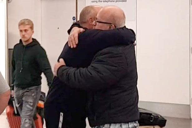 Father-of-four Tony Camoccio embracing friends and family as he arrives back to Gatwick (PA)