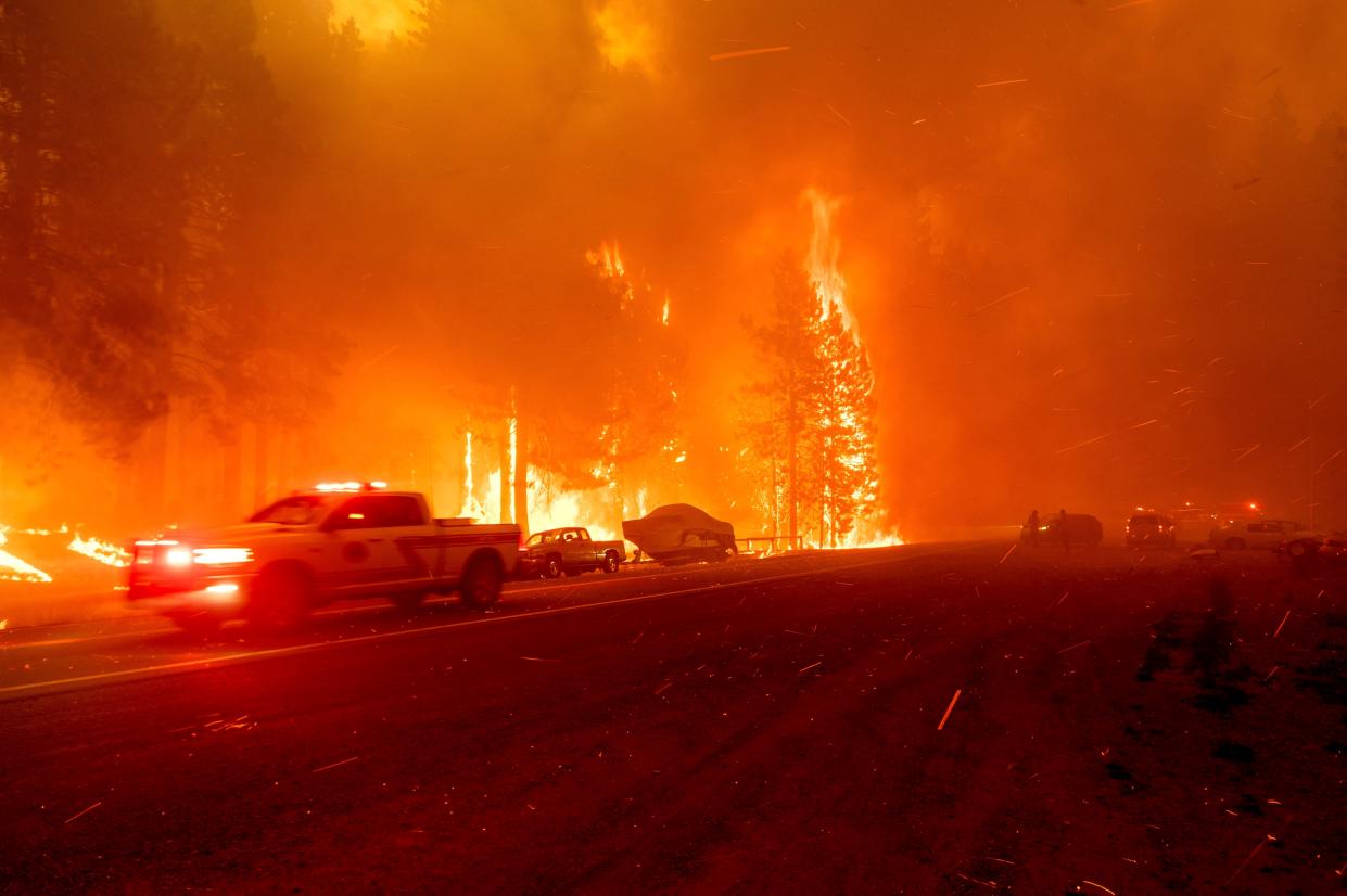 A home and trees burn as the Dixie Fire tears through the Greenville community of Plumas County, Calif. on Wednesday, Aug. 4, 2021. The fire leveled multiple historic buildings and dozens of homes in central Greenville.