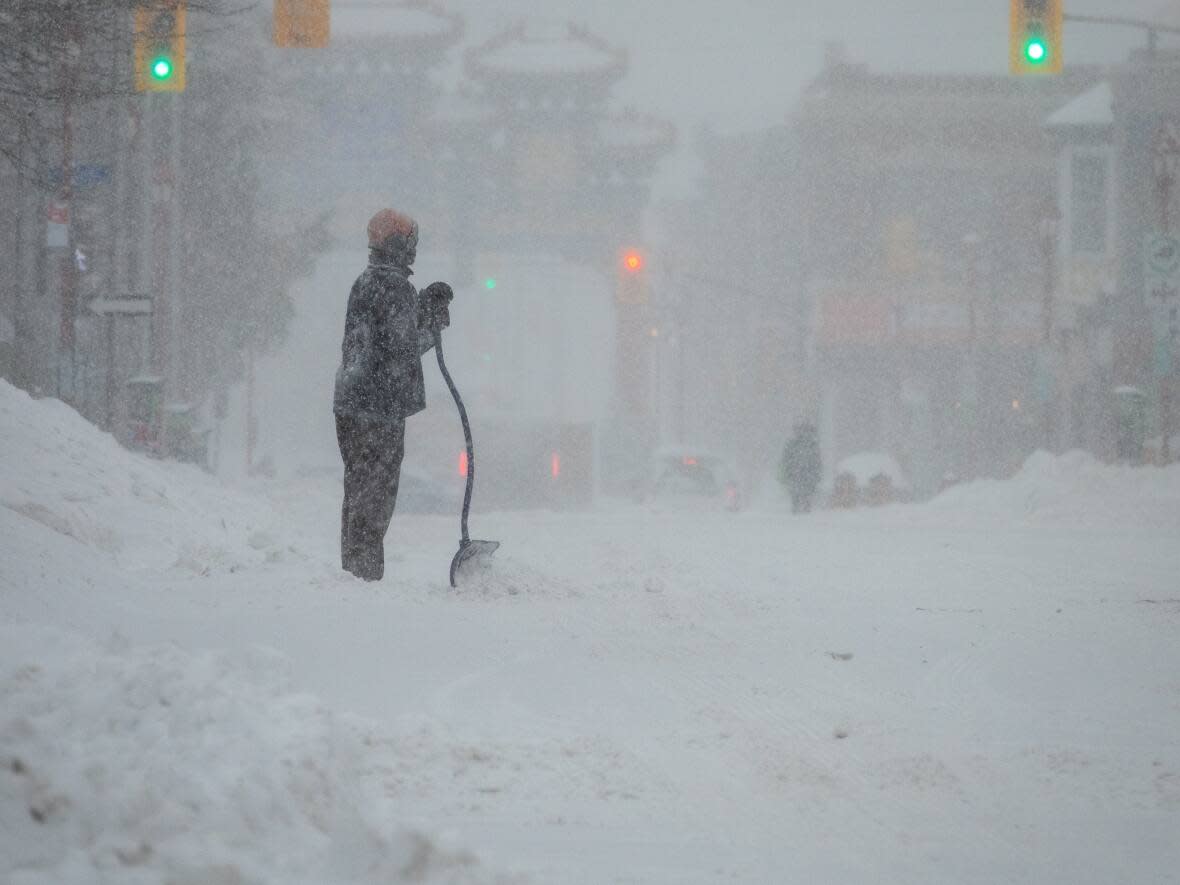 Someone shovels on Ottawa's Somerset Street West on Monday as a blizzard hit the region, closing many COVID-19 vaccine and testing clinics. (Francis Ferland/CBC - image credit)